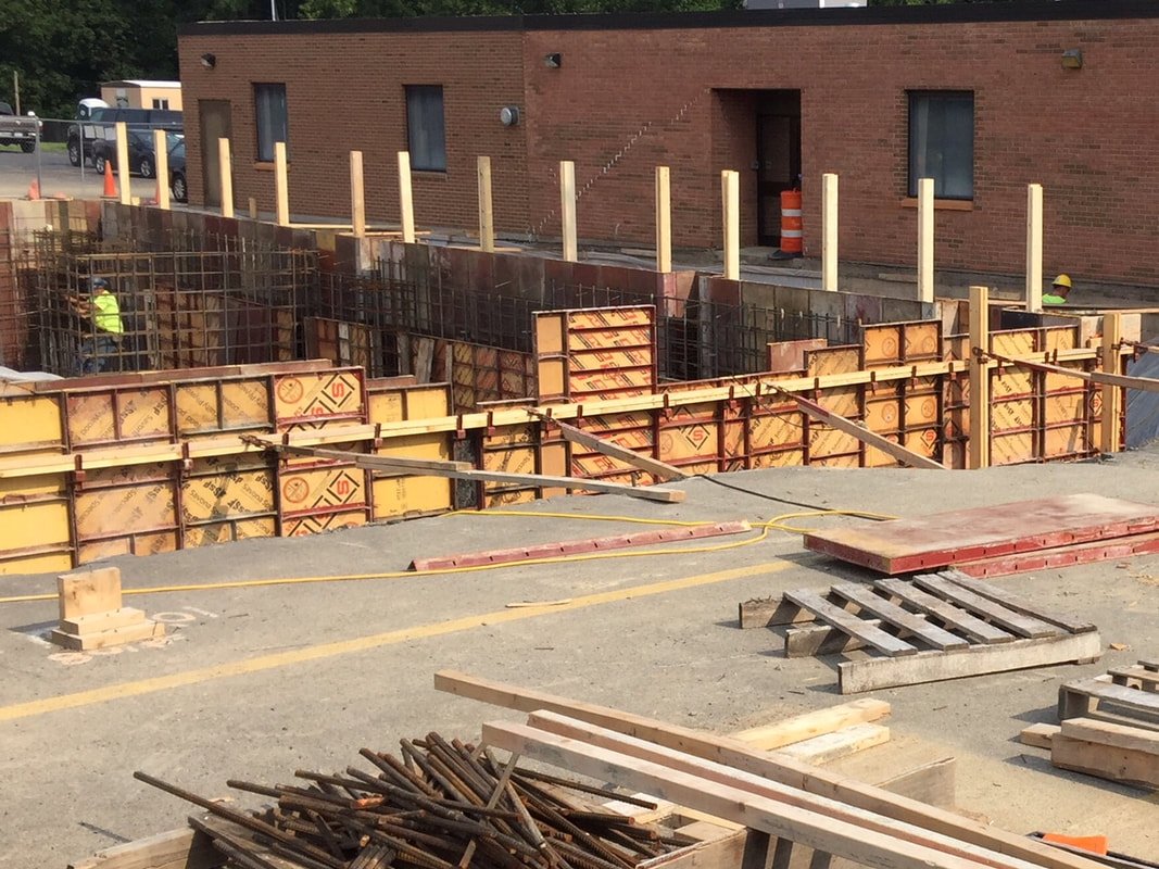 Hand-set concrete wall forms with steel waler frames