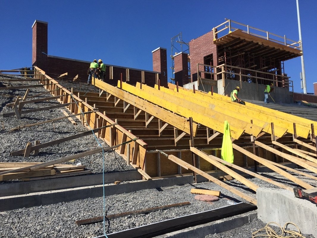 Dimensional lumber, plywood and OSHA plank staged across stadium step forms