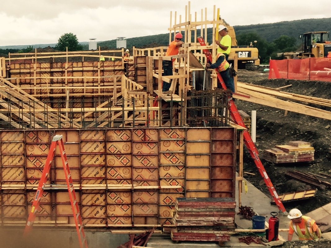 Crew setting steel-framed wall forms on an active jobsite
